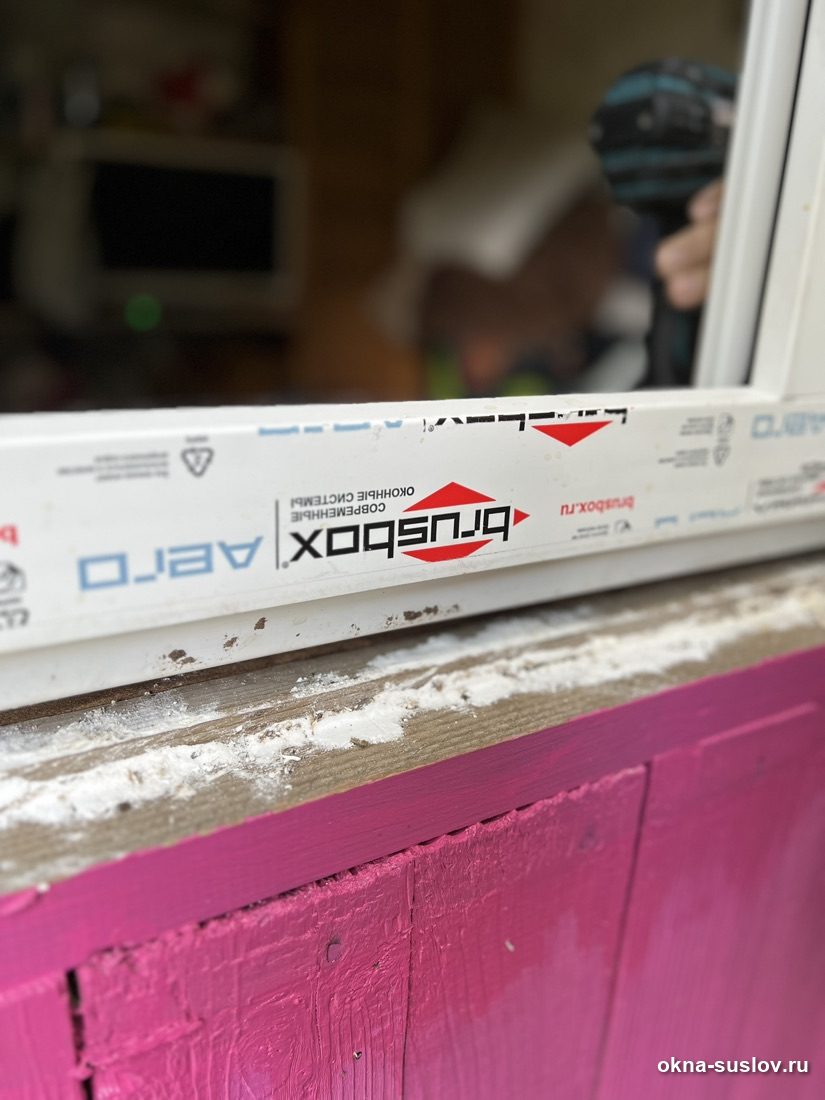Нижний профиль рамы Brusbox в заводской плёнке на старом деревянном основании проёма